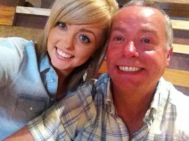 Bright smiling woman and man taking a selfie together, capturing a happy moment at a casual indoor setting.