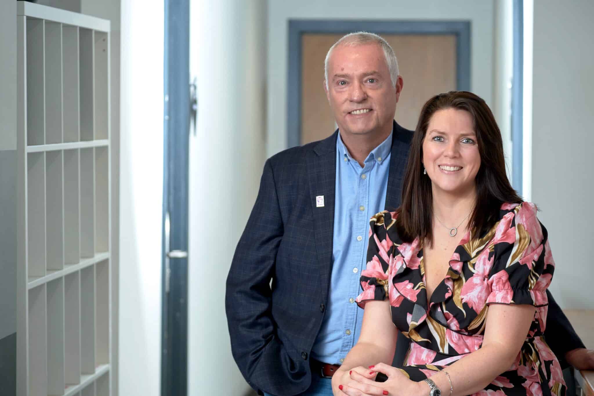 1. Professional team portrait of a man and woman in an office corridor, promoting leadership, teamwork, and professional growth in business environments.